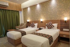 阿鲁法HOTEL VKJ INN Aluva的酒店客房,配有两张床和椅子