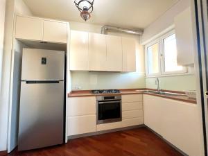 米兰Porta Vittoria Apartments by Accomodo的厨房配有白色橱柜和冰箱。