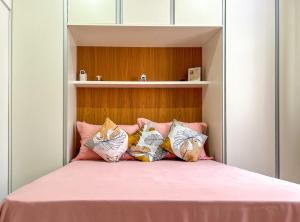 里约热内卢Ótimo studio c WiFi a 190m da Praia do Leme - RJ的一间卧室配有一张带粉色床单和枕头的床。