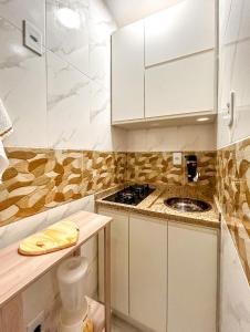 里约热内卢Ótimo studio c WiFi a 190m da Praia do Leme - RJ的小厨房配有白色橱柜和炉灶。