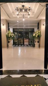 Ban Changเอวา โฮเทล อุดรธานี (AVA Hotel Udonthani)的大堂,在一座建筑里花瓶里放两朵花