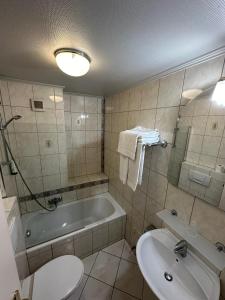 卢森堡亚夏酒店的带浴缸、卫生间和盥洗盆的浴室