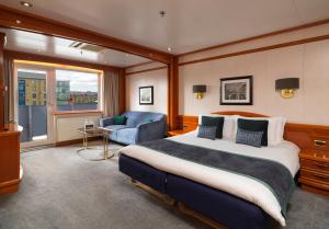 伦敦森伯恩伦敦帆船酒店的一间卧室配有一张床、一张沙发和一把椅子