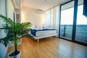 巴统Panorama Orbi Resort的一间卧室配有一张床和盆栽植物