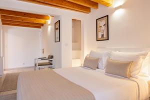 埃尔瓦斯Azinheira Suites Townhouse - Alojamento Turístico的卧室配有白色大床和白色枕头