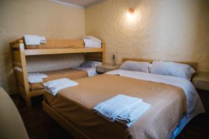 BarraqueroHotel Panamericano的带两张双层床的客房中的两张床