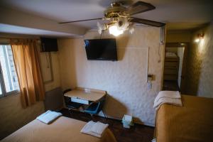 BarraqueroHotel Panamericano的客房设有两张床、一张桌子和一台电视机。