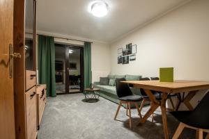 巴德加斯坦Bergblick Appartements的客厅配有绿色沙发和桌子