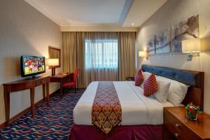 迪拜MD Hotel By Gewan的酒店客房,配有床和电视