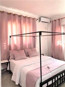 圣路易斯Natoose Lodge的一间卧室配有两张带粉红色窗帘的床