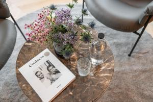 格罗萨尔奈斯勒霍夫酒店的一张带书的玻璃桌和一瓶水