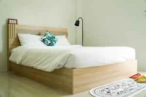 Ban Dam Phraเมตตา เรสซิเด้นซ์ - Metta Residence的一间卧室配有一张大木床和白色床单