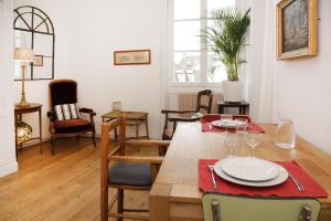 桑利斯Appartements 4 vents by La Boîte En Plus的一间带木桌和椅子的用餐室