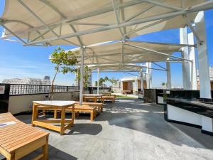 迪拜Placid Studio close to Dubai Miracle Garden的屋顶上设有桌子和长凳的庭院
