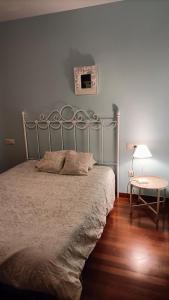 波伊奥Apartamento en Pontevedra con terraza y garaje的一间卧室配有一张床和一张带台灯的桌子