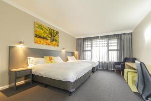 考拉考拉服务俱乐部汽车旅馆的酒店客房设有两张床和窗户。