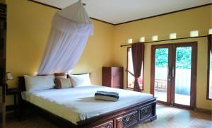 吉利阿尔3号太阳简易别墅酒店的一间卧室配有一张带天蓬的床