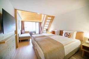 格施塔德Gstaaderhof - Active & Relax Hotel的一间设有大床和楼梯的酒店客房