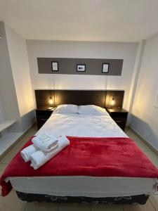 圣萨尔瓦多德朱Apartamentos El Fortín的一间卧室配有一张大床和两条毛巾