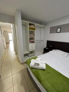 圣萨尔瓦多德朱Apartamentos El Fortín的一间卧室配有一张带绿毯的床