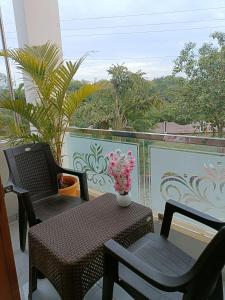 乌贾因Aarav Home Stay的一个带桌子和两把椅子的庭院和一个阳台