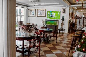 库马西ROYAL PARK HOTEL AND CHINESE RESTAURANT的餐厅设有桌椅和平面电视。