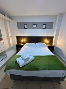 圣萨尔瓦多德朱Apartamentos El Fortín的一间卧室配有一张大床和毛巾