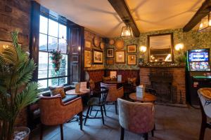 温特沃斯Rockingham Arms By Greene King Inns的一间带桌椅和壁炉的餐厅