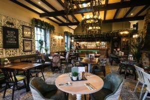 温特沃斯Rockingham Arms By Greene King Inns的一间带桌椅的餐厅和一间酒吧