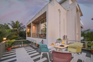 罗纳瓦拉Elegant Villa By Tropicana Stays的房屋设有带桌椅的阳台