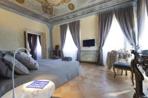 波滕扎皮切纳Stupenda Dimora Italiana Storica的一间卧室设有一张带格子天花板和窗户的床。