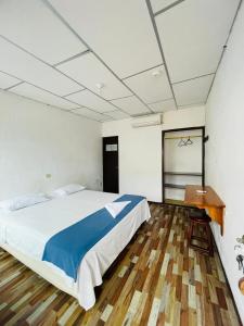 阿约拉港Hostal Darwin B&B的一间卧室设有一张大床,铺有木地板