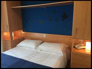 利多迪耶索罗LA MAISON by Hotel Aldebaran的一间卧室配有一张床和一张带电话的书桌