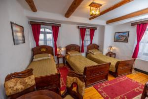 比耶利纳Ethno Village Stanisici的一间卧室配有两张红色窗帘
