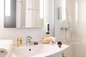 布隆B&B HOTEL Lyon Eurexpo Bron的白色的浴室设有水槽和淋浴。