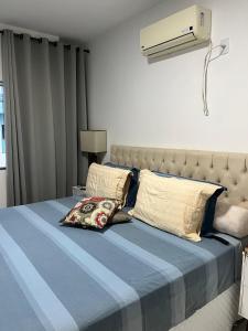 塞古罗港Apartamento 3 Suítes 200mt Axé Moi até 08 pessoas的一间卧室配有一张带蓝色棉被的床和风扇