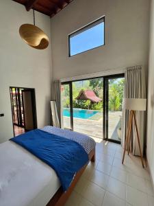 希德门Graha Ayoe的一间卧室配有一张床,享有游泳池的景色