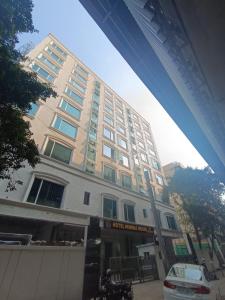 孟买Hotel Mumbai House, Malad的一座白色的大建筑,前面设有停车场