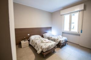 帕尔马G12 Double Rooms l Zona Ospedale Centro l Parking Custodito Privato的一间卧室设有两张床和窗户。