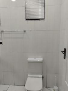 伯诺尼Inspire living home的白色的浴室设有卫生间和窗户。