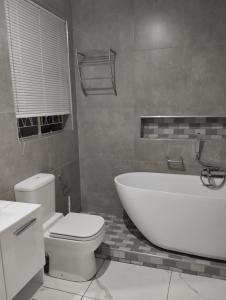 伯诺尼Inspire living home的浴室配有白色浴缸和卫生间。