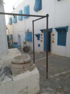 西迪·布·赛义德La maison 4 puits的一座拥有蓝色和白色墙壁和柱子的建筑