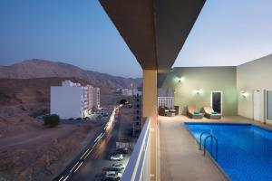 马斯喀特Centara Life Muscat Dunes Hotel的一座带游泳池的城市景观建筑