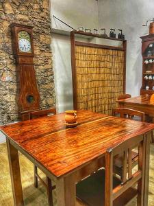 普拉亚Pousada Praia Maria的一张木桌,位于一个钟表的房间