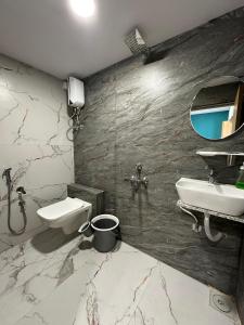 苏拉特Hotel sky palace adajan的一间带水槽、卫生间和镜子的浴室