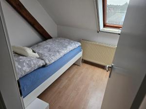 维利希Ferienwohnung Linden 87的一个小房间的小床,设有窗户