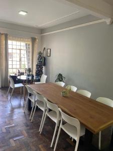 库里提巴Gup Hostel的用餐室配有大型木桌和白色椅子