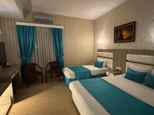 伊斯坦布尔Nil Hotel的酒店客房配有两张床和一张书桌