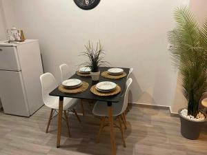 萨索斯Dukas Apartment的餐桌、白色椅子和黑桌