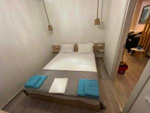 萨索斯Dukas Apartment的小房间的一个床位,上面有蓝色的毛巾